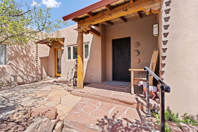 doorway to property featuring stucco siding