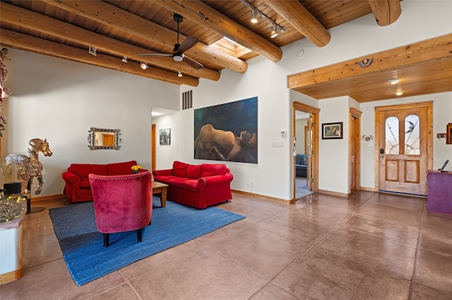 living area featuring rail lighting, beam ceiling, baseboards, wood ceiling, and finished concrete flooring