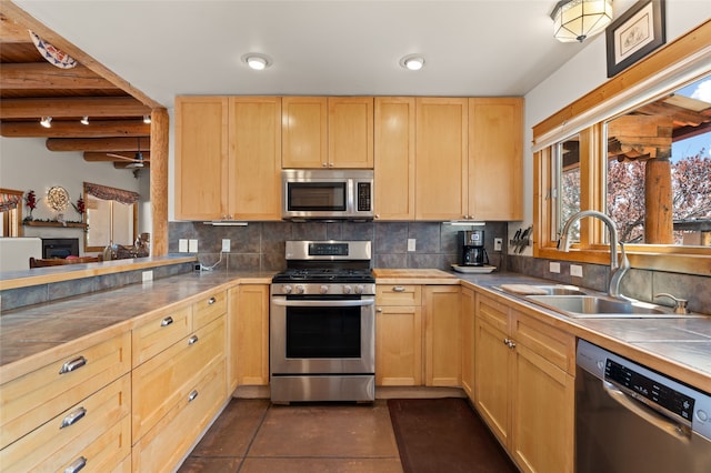 kitchen with light brown cabinetry, a sink, backsplash, and appliances with stainless steel finishes