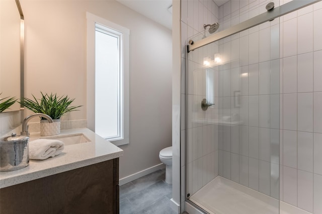 bathroom with toilet, baseboards, vanity, and a stall shower