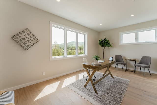 home office with recessed lighting, light wood-style floors, a wealth of natural light, and baseboards