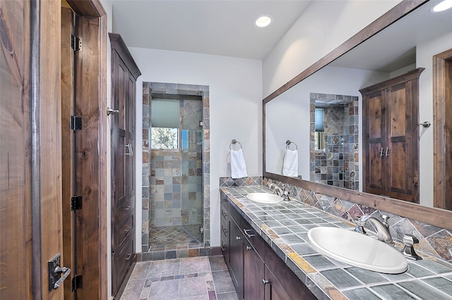 bathroom with recessed lighting, a sink, double vanity, and a stall shower