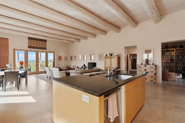kitchen with a sink, beam ceiling, a center island with sink, wood ceiling, and open floor plan