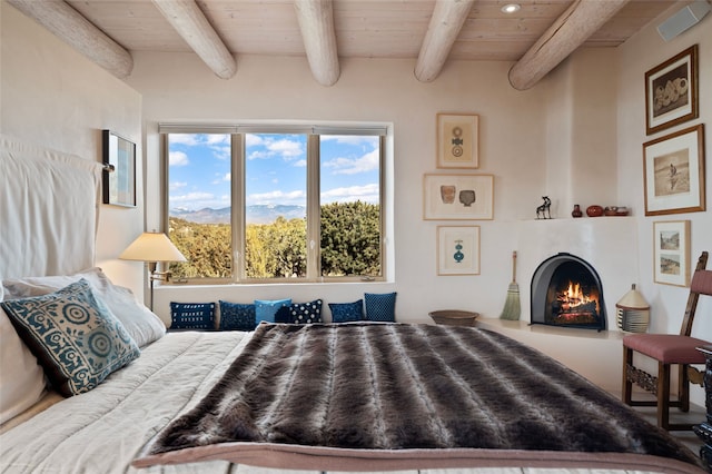 bedroom featuring a warm lit fireplace, beam ceiling, and wood ceiling