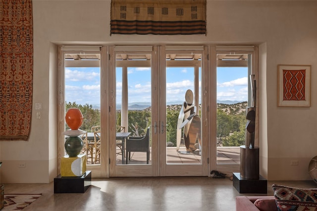 entryway with a mountain view, a healthy amount of sunlight, and french doors