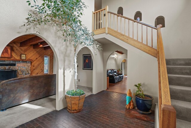 11 Sierra Lejana, Santa Fe, NM 87508 - entrance foyer featuring a fireplace, brick floor, stairway, and a high ceiling