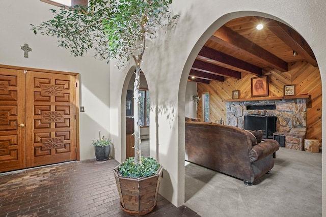 11 Sierra Lejana, Santa Fe, NM 87508 - living area with beam ceiling, arched walkways, wood walls, brick floor, and a fireplace