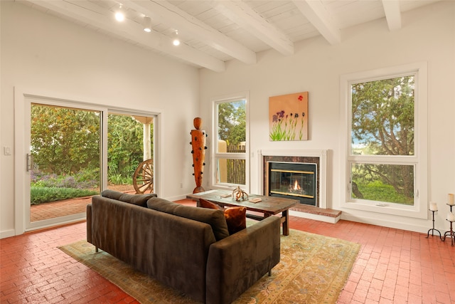 living room with wood ceiling, beamed ceiling, brick floor, and a premium fireplace