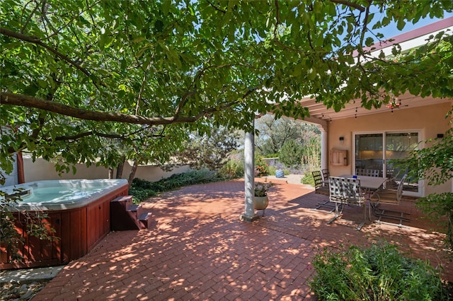 view of patio / terrace with fence, a hot tub, and outdoor dining space