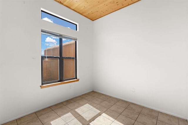tiled spare room with wooden ceiling and baseboards