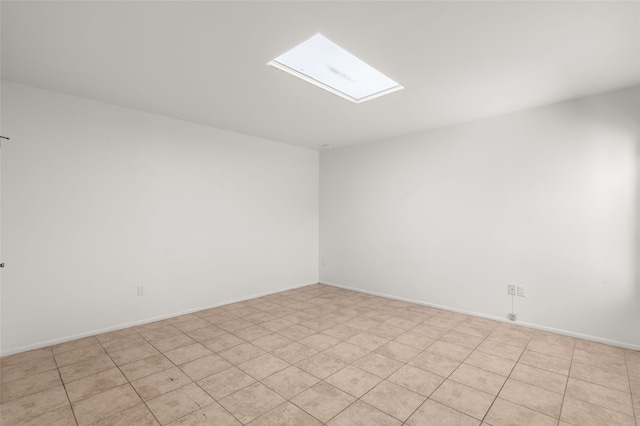 unfurnished room featuring baseboards and a skylight