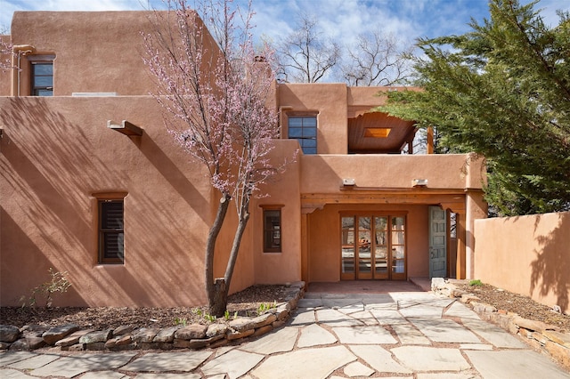 6 El Nido Ln, Santa Fe, NM 87506 - back of house featuring stucco siding, fence, and french doors
