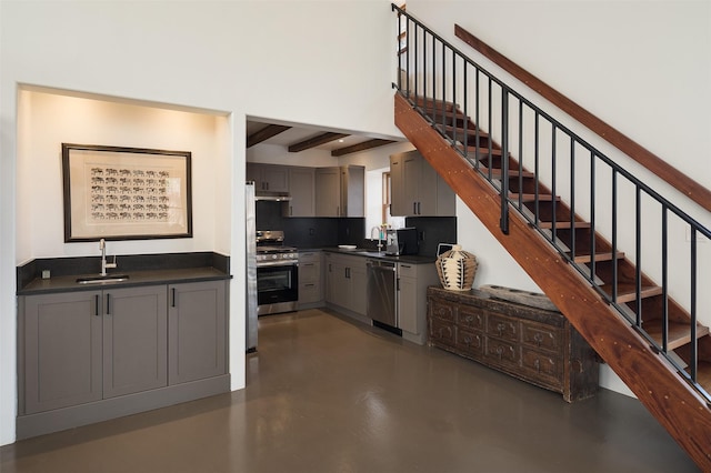 6 El Nido Ln, Santa Fe, NM 87506 - kitchen with dark countertops, gray cabinets, stainless steel appliances, finished concrete flooring, and beam ceiling