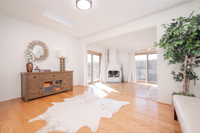 living room with lofted ceiling, a healthy amount of sunlight, and light wood finished floors