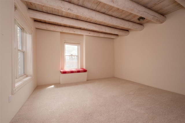 carpeted empty room with beamed ceiling and wooden ceiling