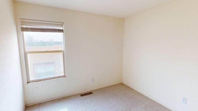 spare room with visible vents and carpet