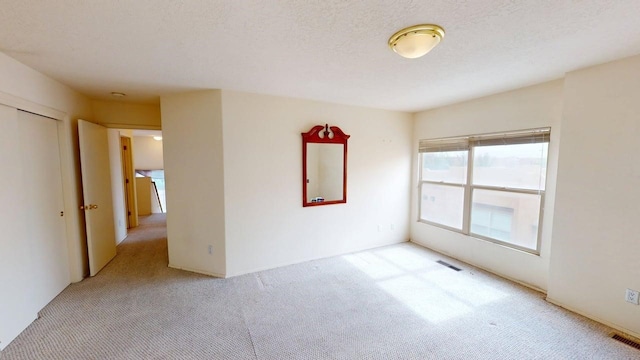 spare room with light colored carpet and visible vents