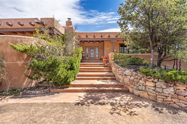 doorway to property featuring a chimney and fence