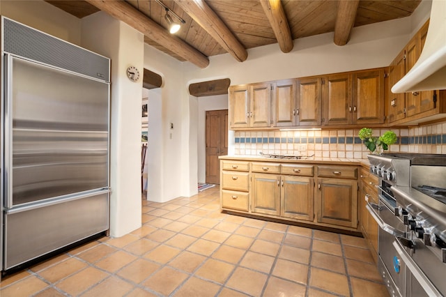 kitchen featuring high quality appliances, beamed ceiling, wooden ceiling, backsplash, and range hood