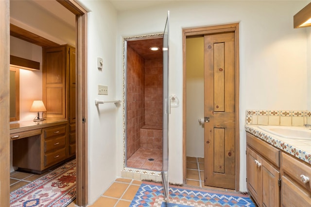 bathroom featuring vanity, tile patterned flooring, and a tile shower