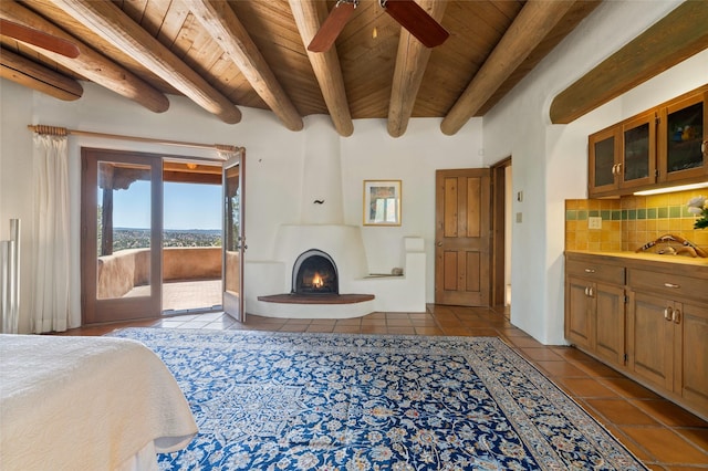 bedroom featuring wooden ceiling, access to outside, dark tile patterned floors, and beamed ceiling