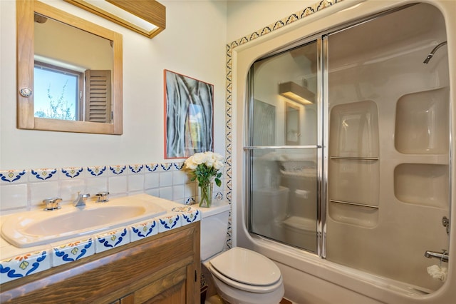 full bathroom featuring vanity, enclosed tub / shower combo, and toilet