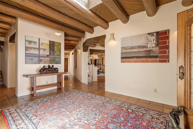 hall featuring beamed ceiling, tile patterned floors, and wooden ceiling