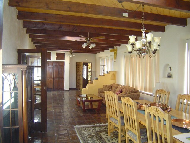 dining room with ceiling fan with notable chandelier, wooden ceiling, and beam ceiling