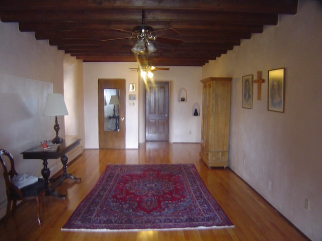 entrance foyer with wood finished floors, beam ceiling, and a ceiling fan