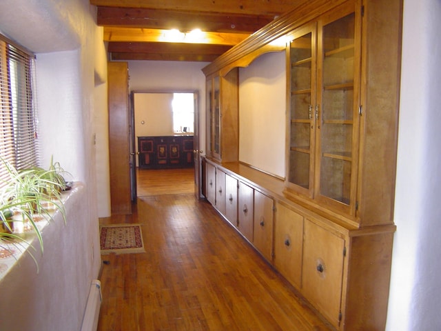 hallway featuring wood finished floors, beam ceiling, and baseboard heating