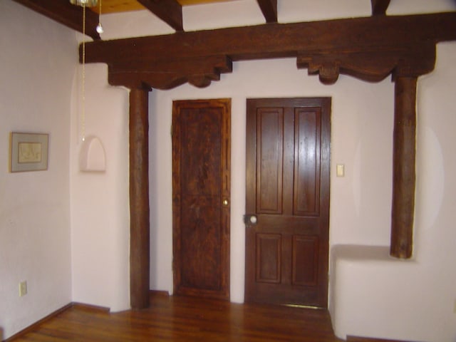 hallway featuring beamed ceiling and wood finished floors