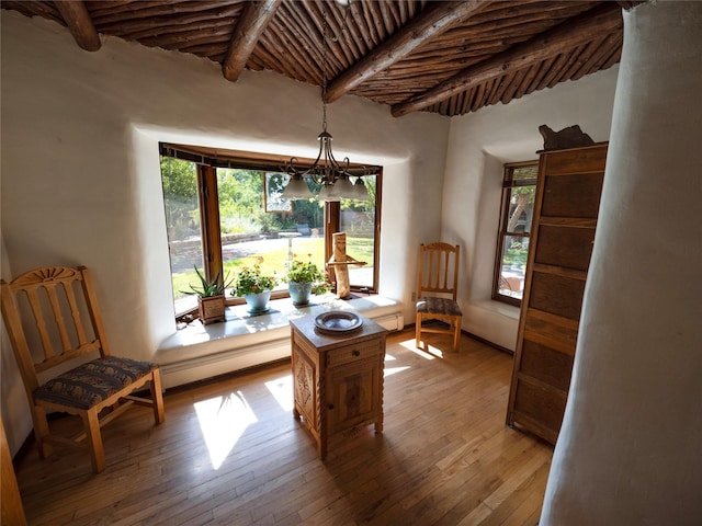 dining room with a baseboard heating unit, light wood-style flooring, and beam ceiling