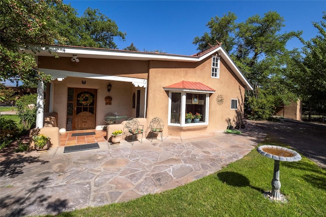 view of front of home with a patio and stucco siding