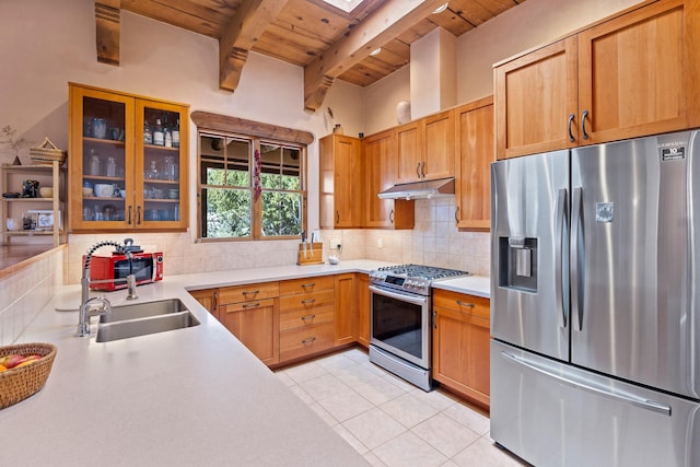 kitchen featuring beam ceiling, a sink, wooden ceiling, under cabinet range hood, and appliances with stainless steel finishes