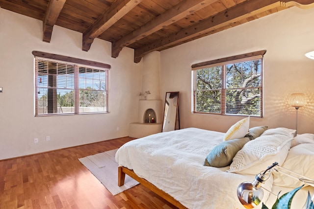 bedroom with wood ceiling, wood finished floors, and beamed ceiling