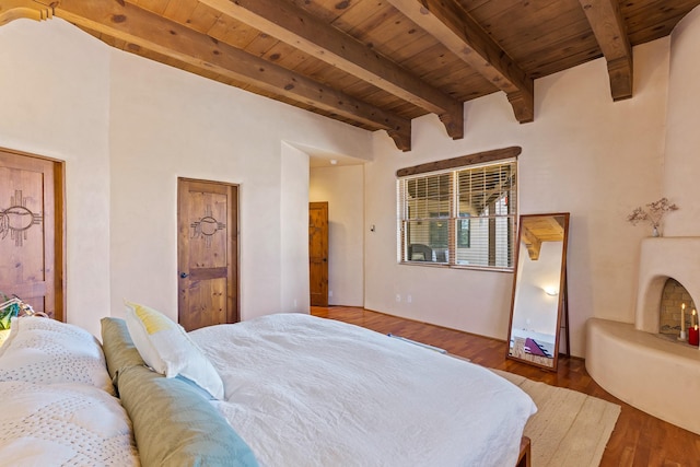 bedroom with wood ceiling, wood finished floors, and beam ceiling