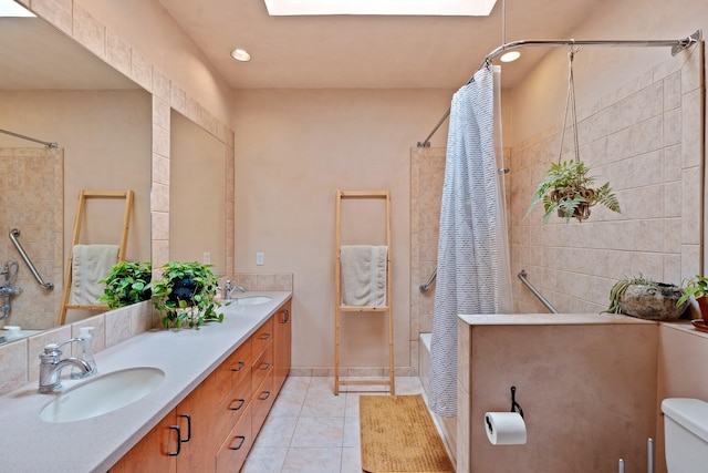 full bath with tile patterned floors, a sink, double vanity, and toilet