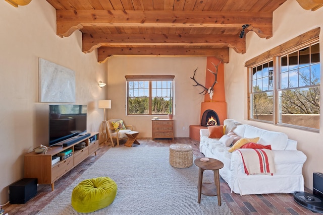 living area with wood ceiling, a lit fireplace, wood finished floors, and beamed ceiling