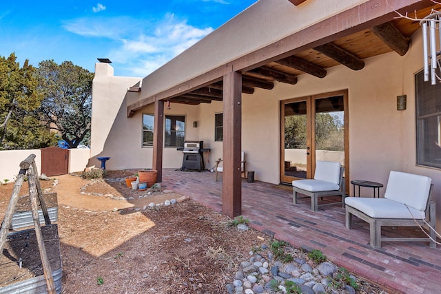 view of patio / terrace with fence, french doors, and a grill