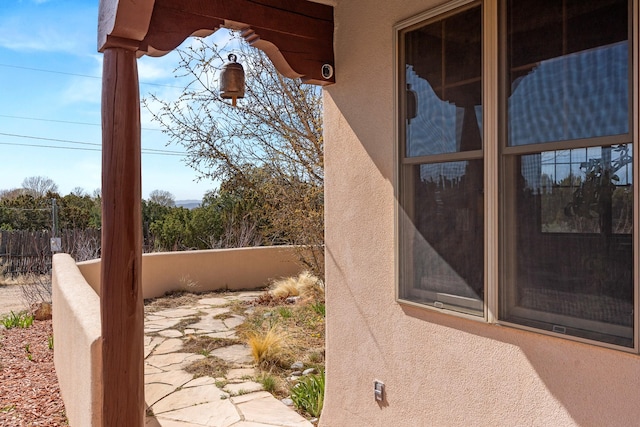 exterior space featuring stucco siding and fence