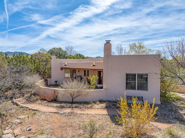 view of home's exterior with stucco siding and a chimney