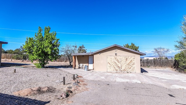 exterior space featuring a storage shed, concrete driveway, and fence
