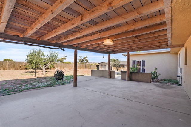 view of patio with an outdoor structure, a fenced backyard, and a storage shed
