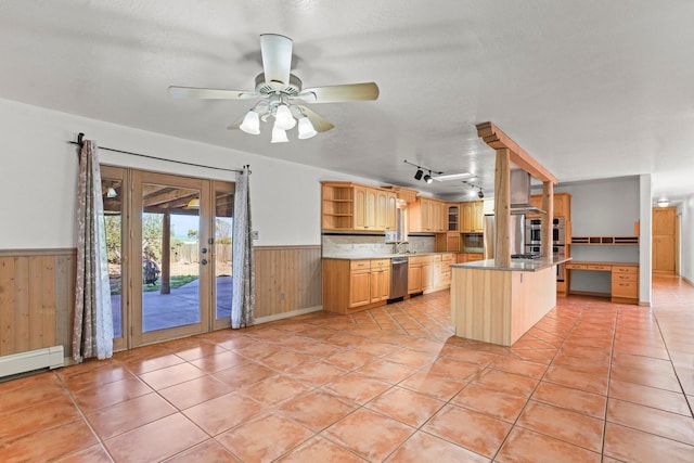 kitchen featuring french doors, stainless steel dishwasher, wainscoting, wood walls, and open shelves