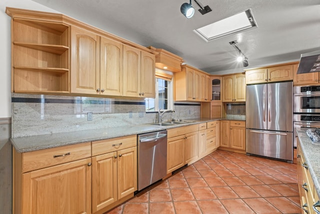 kitchen with light brown cabinets, tasteful backsplash, stainless steel appliances, and a sink