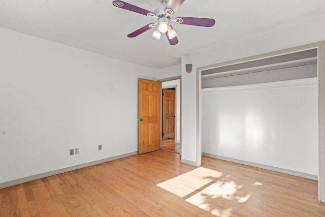 unfurnished bedroom with wood finished floors, a closet, baseboards, and ceiling fan