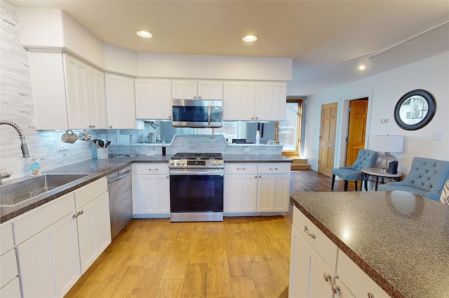 4715 Quemazon, Los Alamos, NM 87544 - kitchen featuring dark countertops, a sink, light wood-type flooring, tasteful backsplash, and appliances with stainless steel finishes