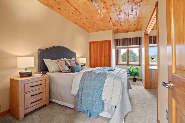 bedroom with wood ceiling, baseboards, track lighting, and light colored carpet