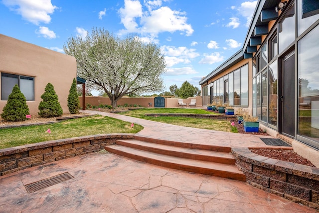exterior space featuring a fenced backyard, a shed, an outbuilding, and a patio