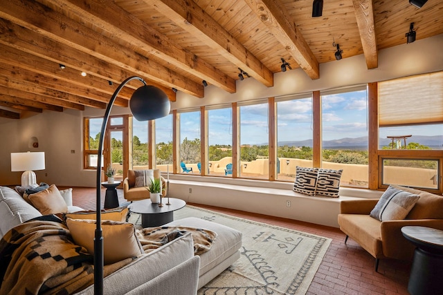 sunroom with beamed ceiling and a mountain view